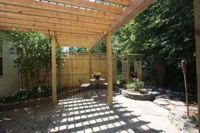 Diseño de patio de tamaño medio en patio trasero con suelo de hormigón estampado y pérgola