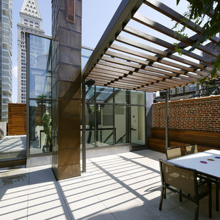Esempio di un ampio patio o portico minimal con una pergola