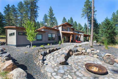 Example of a large trendy backyard stone patio design in Seattle with a fire pit and a roof extension