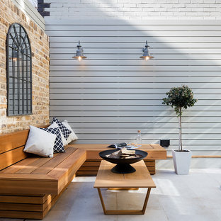 Esempio di un piccolo patio o portico chic dietro casa con un focolare e pavimentazioni in pietra naturale
