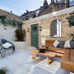 Foto di un piccolo patio o portico tradizionale dietro casa con un focolare, pavimentazioni in cemento e nessuna copertura