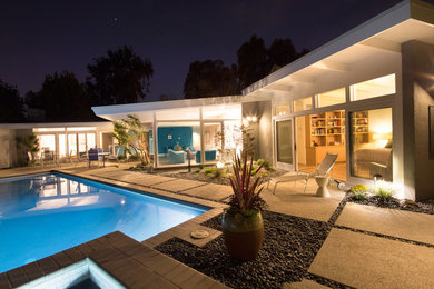 Aménagement d'une terrasse arrière rétro de taille moyenne avec des pavés en béton.