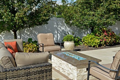 Inspiration for a timeless backyard patio remodel in New York with a fire pit