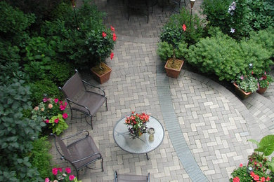 Immagine di un piccolo patio o portico contemporaneo dietro casa con un giardino in vaso, pavimentazioni in mattoni e nessuna copertura