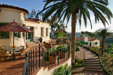 Mittelgroßer, Unbedeckter Mediterraner Patio hinter dem Haus mit Kübelpflanzen und Pflastersteinen in San Diego