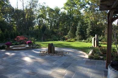 Patio - mid-sized transitional backyard stone patio idea in Other with no cover and a fire pit