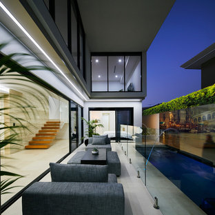 Photo of a contemporary courtyard patio in Perth with tile and a roof extension.