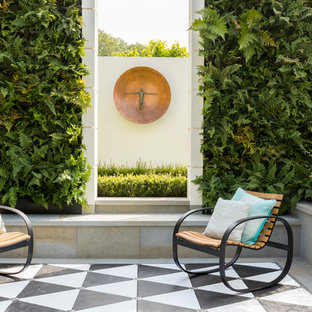 Design ideas for a contemporary patio in London with a living wall and tiled flooring.