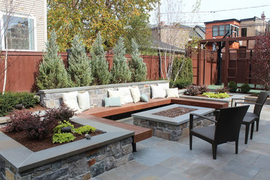 Example of a mid-sized trendy backyard stone patio design in Chicago with a fire pit and no cover