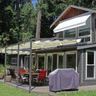 Immagine di un patio o portico stile americano di medie dimensioni e dietro casa con un parasole e pavimentazioni in cemento