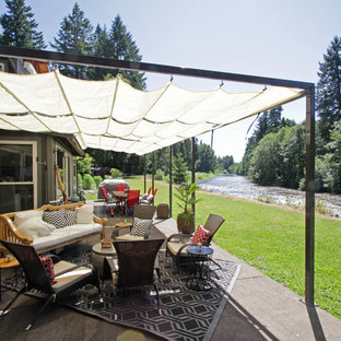 Idee per un patio o portico stile americano di medie dimensioni e dietro casa con pavimentazioni in cemento e un parasole