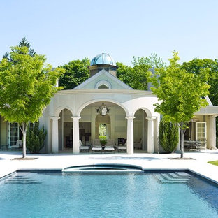 Foto di un ampio patio o portico chic dietro casa con pavimentazioni in cemento e un tetto a sbalzo