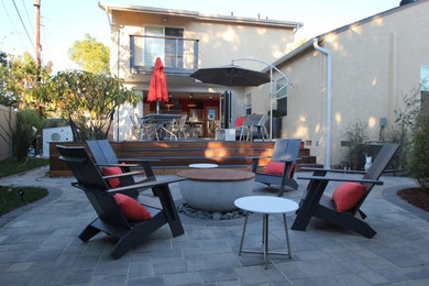 Large trendy backyard concrete paver patio photo in Los Angeles with a fire pit and no cover