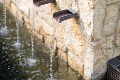 Patio fountain - mid-sized mediterranean backyard stone patio fountain idea in Orange County with no cover