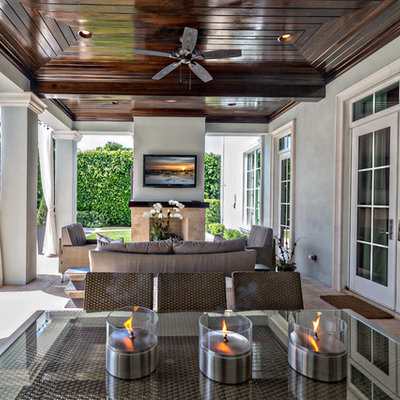 Inspiration for a large transitional backyard tile patio remodel in Miami with a fire pit and a roof extension