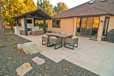 Example of a trendy backyard tile patio design in Boise with a fire pit