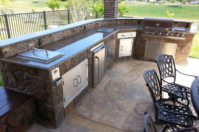 Inspiration for a timeless backyard stamped concrete patio kitchen remodel in New York with a pergola