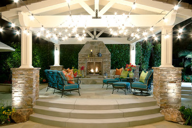 Large beach style backyard stone patio photo in San Diego with a fire pit and a pergola