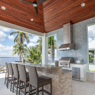 Foto de patio tropical, de tamaño medio, en anexo de casas, con cocina exterior y suelo de baldosas