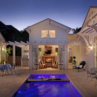 Immagine di un patio o portico tropicale con una pergola e un focolare