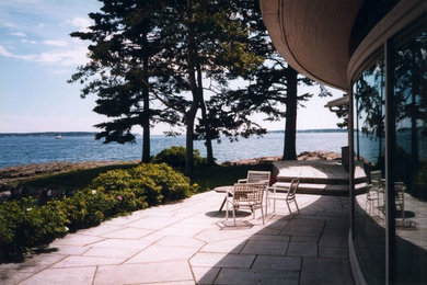Réalisation d'une terrasse minimaliste avec des pavés en pierre naturelle et une extension de toiture.