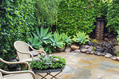 Inspiration for a mid-sized contemporary courtyard stone patio fountain remodel in Los Angeles with no cover