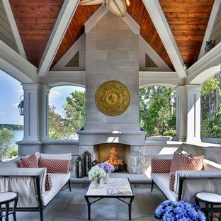 Ispirazione per un patio o portico mediterraneo di medie dimensioni e dietro casa con pavimentazioni in pietra naturale, un gazebo o capanno e un caminetto