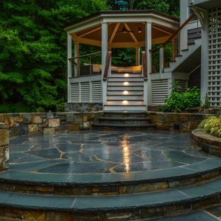 Esempio di un grande patio o portico minimal dietro casa con un focolare, pavimentazioni in pietra naturale e un gazebo o capanno