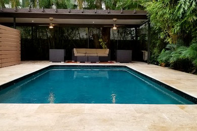 Ejemplo de piscina clásica renovada de tamaño medio en patio trasero con suelo de baldosas