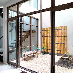 Idee per un grande patio o portico etnico in cortile con ghiaia e un tetto a sbalzo
