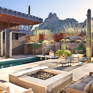 Idee per un ampio patio o portico stile americano dietro casa con pavimentazioni in pietra naturale, nessuna copertura e un focolare