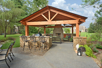 Large mountain style backyard stamped concrete patio kitchen photo in Other with a gazebo