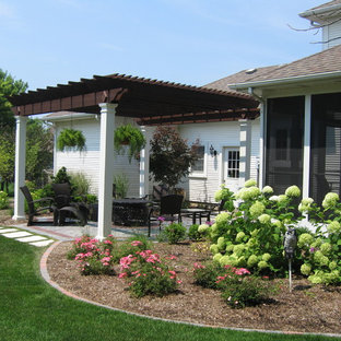 Idee per un patio o portico stile shabby di medie dimensioni e dietro casa con pavimentazioni in mattoni e una pergola