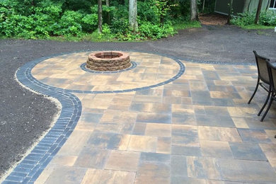 Patio - large transitional backyard concrete paver patio idea in Grand Rapids with a fire pit and no cover