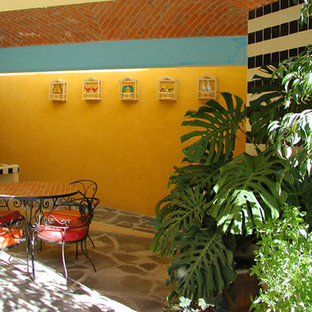 Mid-sized tuscan courtyard patio container garden photo in Austin with a roof extension