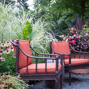 Immagine di un ampio patio o portico mediterraneo dietro casa con un giardino in vaso, graniglia di granito e nessuna copertura
