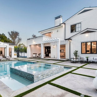 Ispirazione per un grande patio o portico minimal dietro casa con un caminetto, pavimentazioni in cemento e un gazebo o capanno