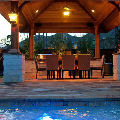 Patio kitchen - traditional patio kitchen idea in Houston with a pergola
