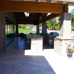 Esempio di un grande patio o portico stile americano dietro casa con piastrelle e un tetto a sbalzo