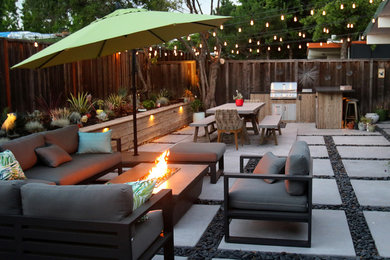 Ejemplo de patio minimalista grande sin cubierta en patio trasero con cocina exterior y losas de hormigón