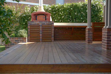 Aménagement d'une terrasse en bois arrière contemporaine de taille moyenne avec une cuisine d'été et une extension de toiture.