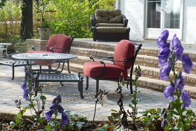 Imagen de patio clásico de tamaño medio en patio trasero con adoquines de hormigón