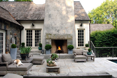 Example of a classic patio design in New York with a fire pit and no cover
