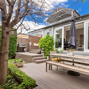 Idee per un patio o portico nordico di medie dimensioni e dietro casa con pedane e nessuna copertura