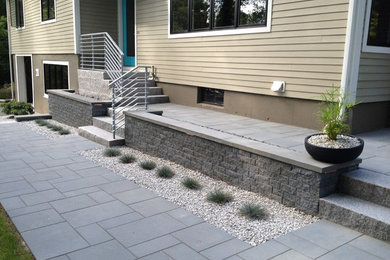 Example of a mid-sized trendy front yard stamped concrete patio design in Boston with no cover