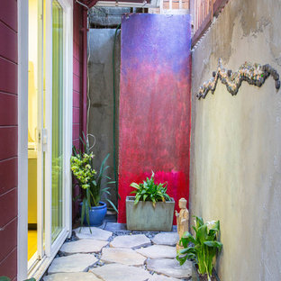 Ispirazione per un piccolo patio o portico eclettico in cortile con pavimentazioni in pietra naturale e un tetto a sbalzo