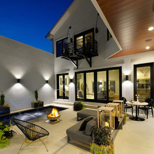 Idee per un patio o portico minimal dietro casa con fontane, un tetto a sbalzo e lastre di cemento