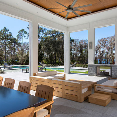 Example of a trendy backyard patio design in Orlando with a fire pit and a roof extension