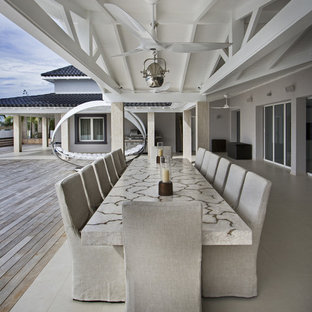 Réalisation d'une très grande terrasse arrière design avec une extension de toiture.