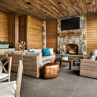 Foto di un grande patio o portico country dietro casa con cemento stampato e un tetto a sbalzo
